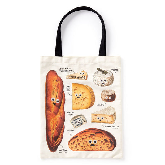 The Brass Monkey Googly Food Canvas Tote is a cream bag with black handles, showcasing googly-eyed bread and cheese illustrations with funny speech bubbles for a playful, foodie twist on your daily style.