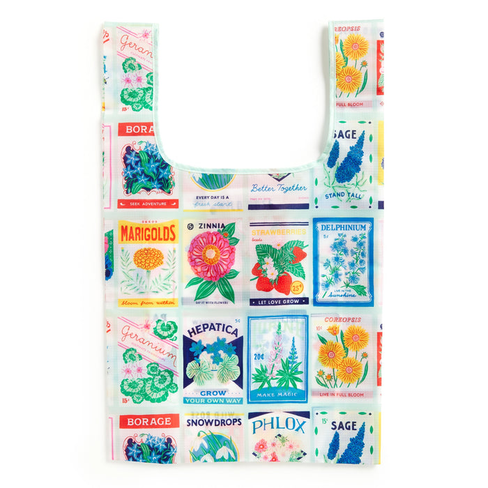 The Grow Your Own Way Packable Nylon Tote Bag by Emily Taylor features eco-friendly materials and vibrant vintage-style seed packet illustrations of marigolds, zinnia, sage, borage, geranium, hepatica, snowdrops, and phlox.