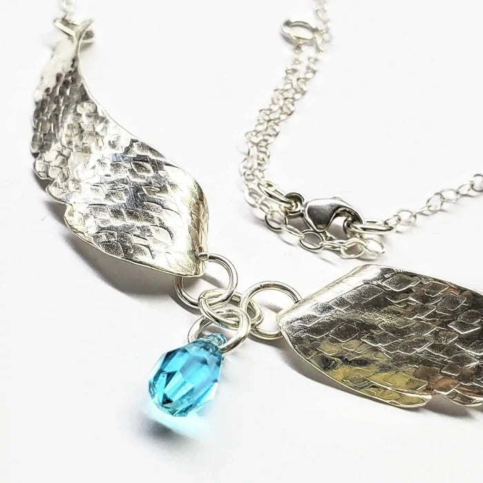 Handmade Silver Forged Sculpted Angel Wings Necklace with blue Swarovski crystal teardrop and detailed silver wings.
