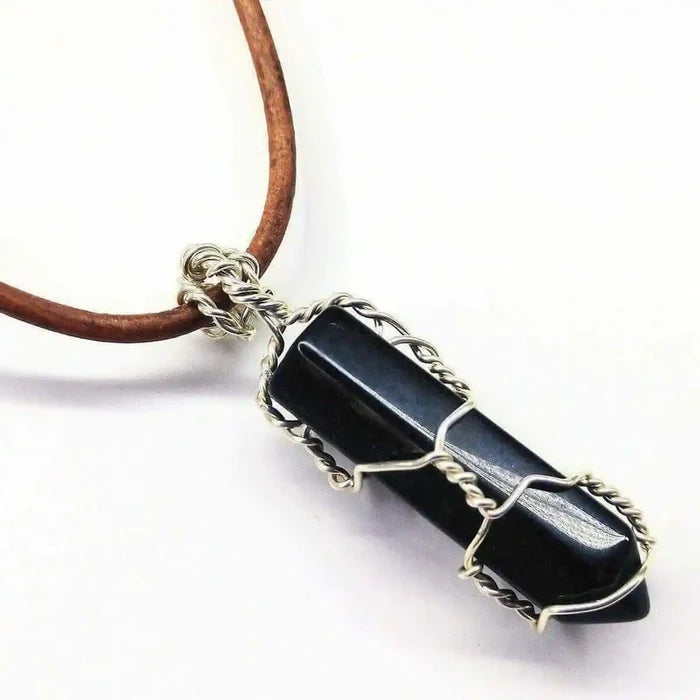 Handmade Silver Wire Wrapped Gemstone Crystal Point Pendant featuring a dark crystal encased in wire.