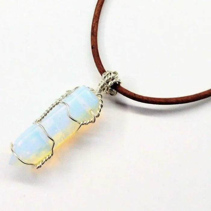 Handmade Silver Wire Wrapped Gemstone Crystal Point Pendant displayed on a brown cord necklace with a blue opal crystal.