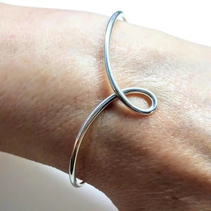 Handmade Wire Sculpted Silver Teardrop Bangle worn on a wrist, showcasing its elegant and artistic design.
