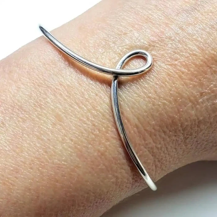 Handmade Wire Sculpted Silver Teardrop Bangle displayed on a wrist, showcasing its elegant design and craftsmanship.