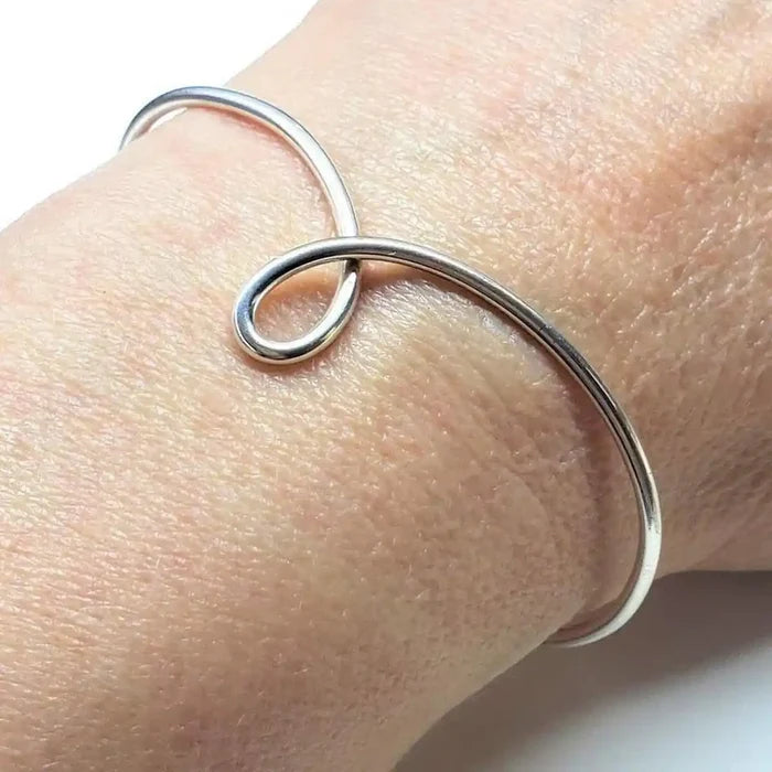 Handmade Wire Sculpted Silver Teardrop Bangle worn on wrist showcasing elegant design.