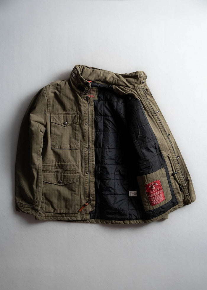 Olive green jacket with black quilted lining, open to reveal a red label. Features buttoned pockets and a high collar.