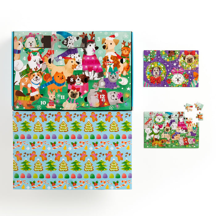 The Kathryn Selbert Ho Ho Howl! Countdown Puzzle Set features a festive advent calendar with dogs in winter wear, numbered doors, and two partially completed holiday dog puzzles on a decorated backdrop for family puzzle fun.