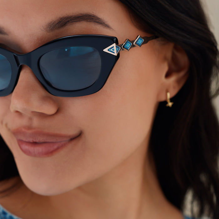 lifestyle - female wearing diff eyewear x disney princess featuring the jasmine 2.0 cateye sunglasses with a black acetate frame and teal lenses detailed temple view