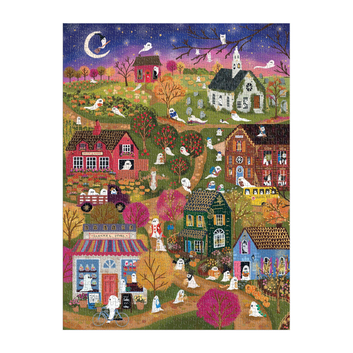 The Joy Laforme Spooky Village 1000 Piece Foil Puzzle features a whimsical Halloween night scene with purple skies, a crescent moon, and friendly ghosts among houses—perfect for festive fun from artist Joy Laforme.