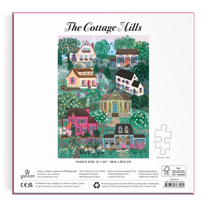 The back of the Joy Laforme The Cottage Hills 1000 Piece Puzzle in a Square Box shows colorful cottages amid trees and flowers, with the puzzle title above, plus product info and a jigsaw piece outline below.