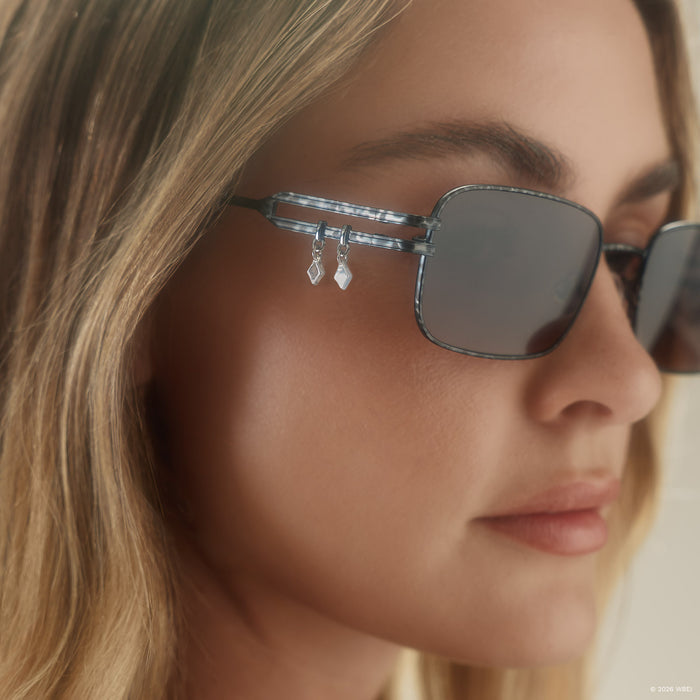 on model - blonde female wearing diff eyewear x practical magic kylie rectangle sunglasses with a gunmetal frame and mauve lenses detailed view