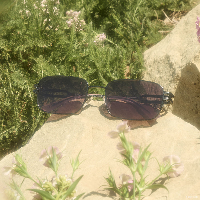 still life - diff eyewear x practical magic kylie rectangle sunglasses laying on a rock outdoors