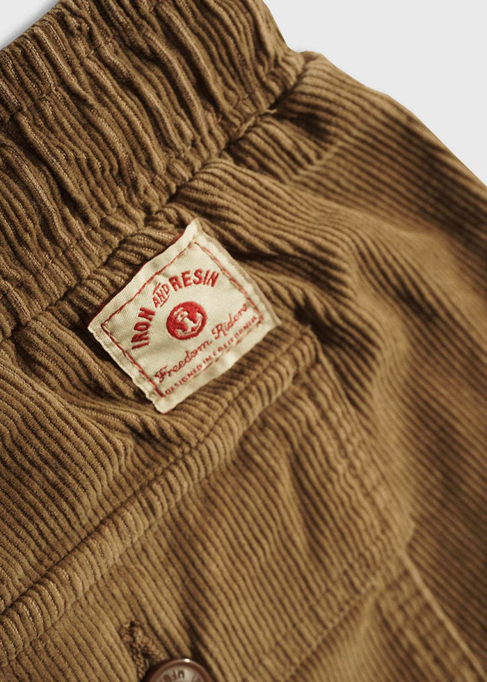 Close-up of men’s 14 wale corduroy shorts elastic waistband, custom tag and durable workwear inspired short