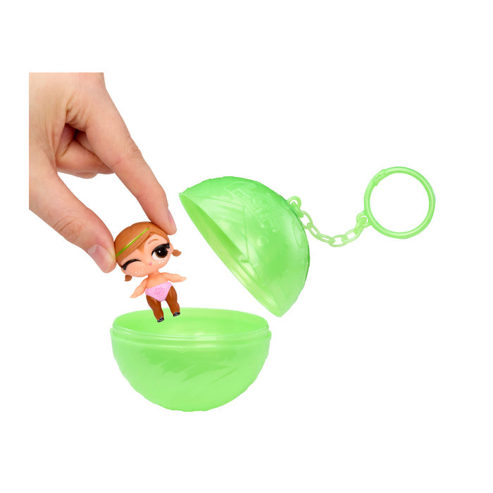 Hand picking up doll out of green ball on a white background