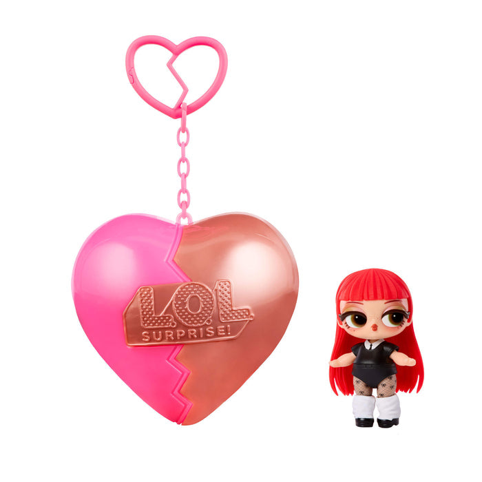 Small doll with red hair with a heart shaped keychain on a white background