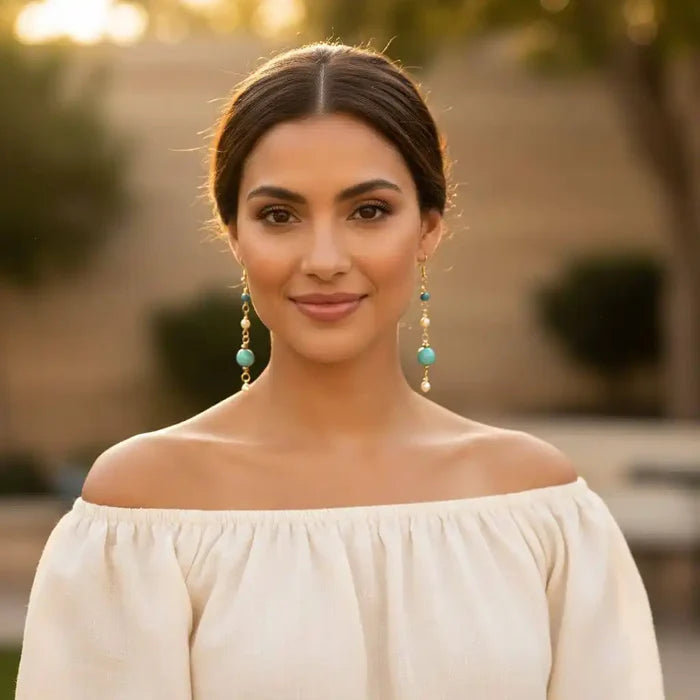 Model wearing Long 14 K Gold Filled Turquoise Pearl Earrings, showcasing elegance and style in outdoor setting.