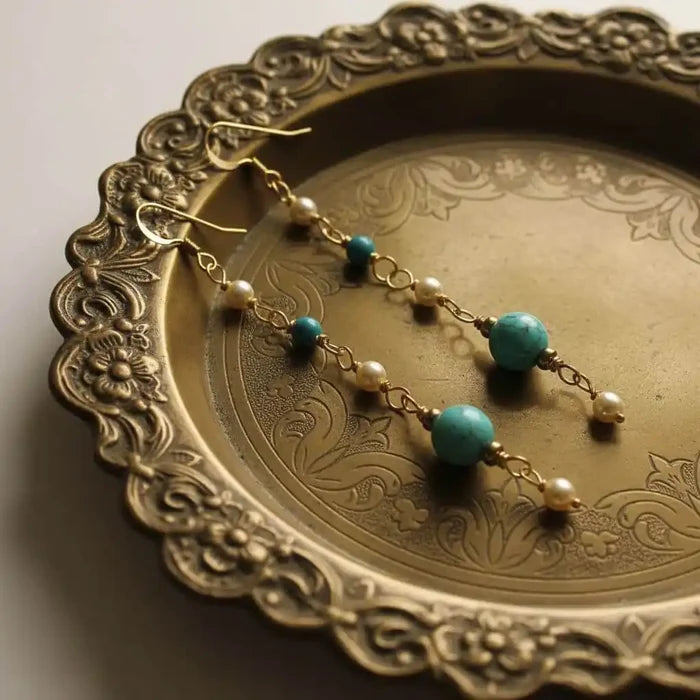 Long 14 K Gold Filled Turquoise Pearl Earrings displayed on an ornate gold plate.