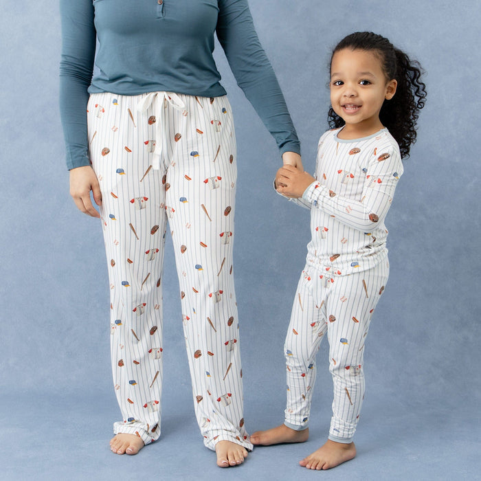 Female wearing the Women's Lounge Pants in Home Run holding the hand of her daughter who is matching in long sleeve pajamas