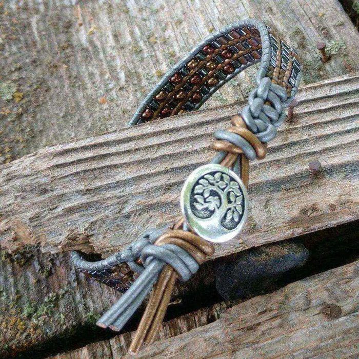 Men's Intricately Beaded Leather Tree of Life Bracelet on rustic wood background