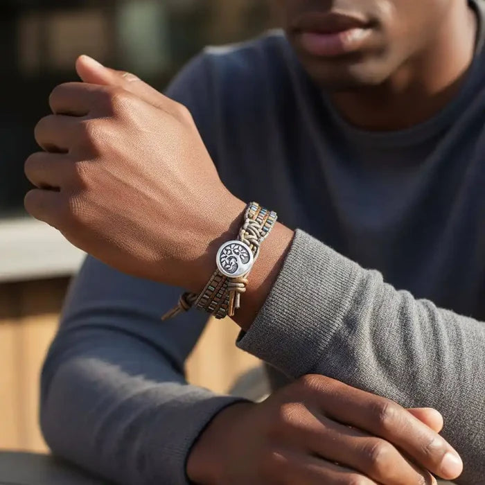 Close-up of a man wearing the Men's Intricately Beaded Leather Tree of Life Bracelet with beaded details.