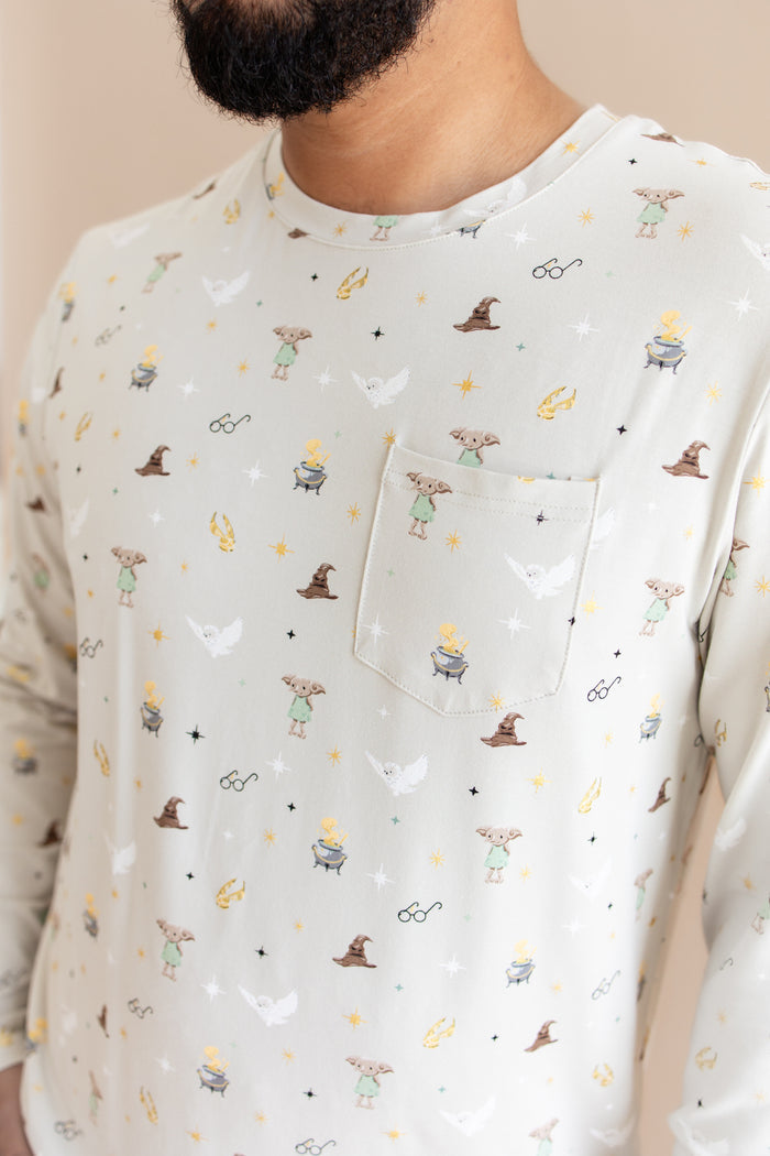 Person wearing a men's jogger set pocket shirt having Harry Potter prints on a cream fabric