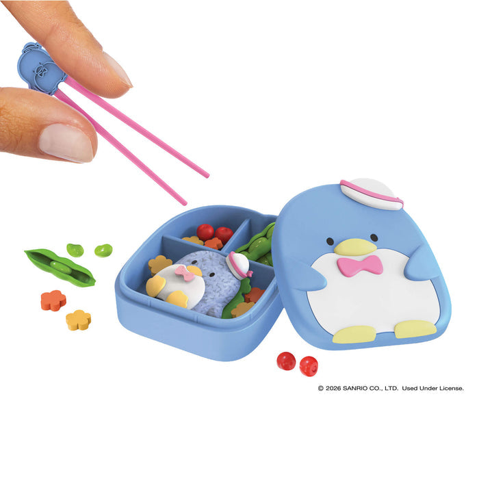 Blue penguin-themed bento box with compartments and a pair of pink chopsticks on a white background.