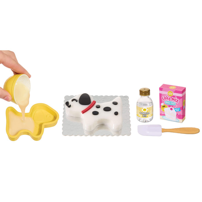 Baking set with a dog-shaped cake, yellow pan, bottle, and box on a white background