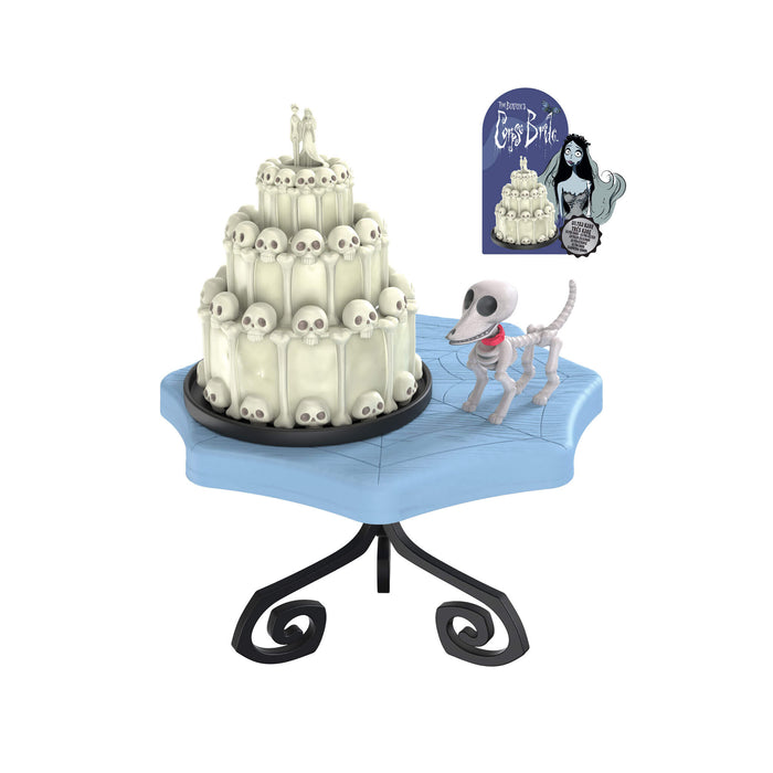 Bone looking dog on blue table with a skull cake on a white background