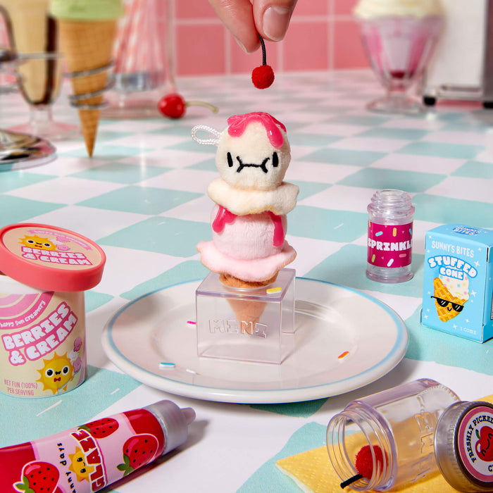 Toy figure of a character on an ice cream cone with a checkered tablecloth and ice cream-themed decor.