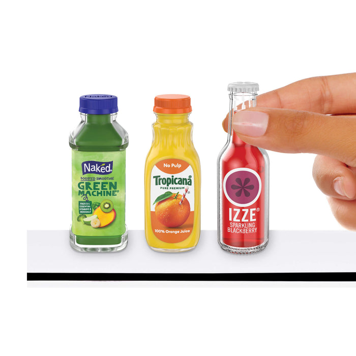 Three miniature juice bottles from Naked, Tropicana, and IZZE on a white background with a hand holding one of them.