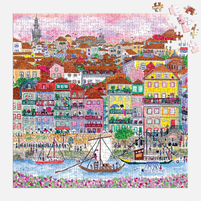 The Michael Storrings Colors of Porto 500 Piece Puzzle by Michael Storrings features a lively riverside town scene; several pieces are missing in the upper right corner.