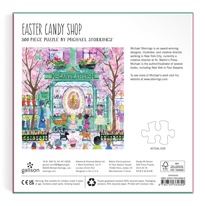The puzzle box displays vibrant artwork of the Michael Storrings Easter Candy Shop, with children and adults outside. It highlights the artist, features 500 pieces, and includes an image showing the exact size of the puzzle pieces. Brand: Michael Storrings.