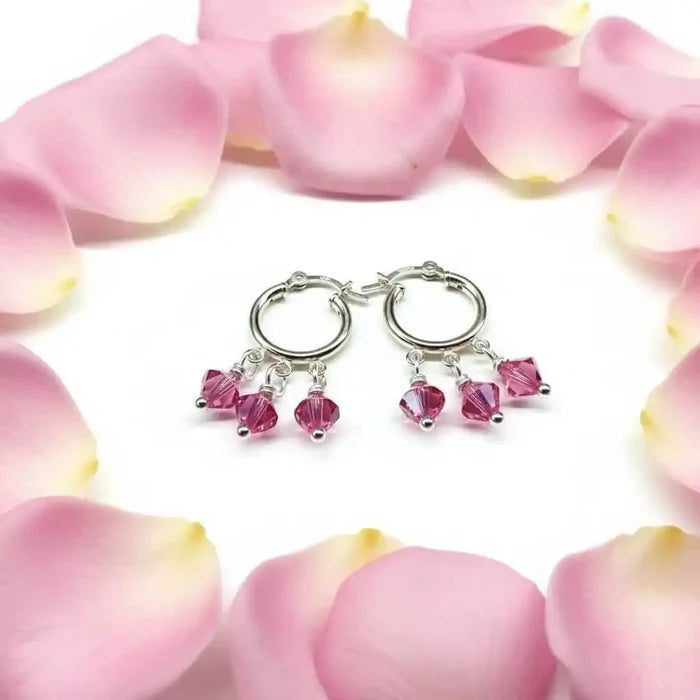 Mini Sterling Silver Hoop Pink Crystal Dangle Earrings surrounded by pink rose petals.
