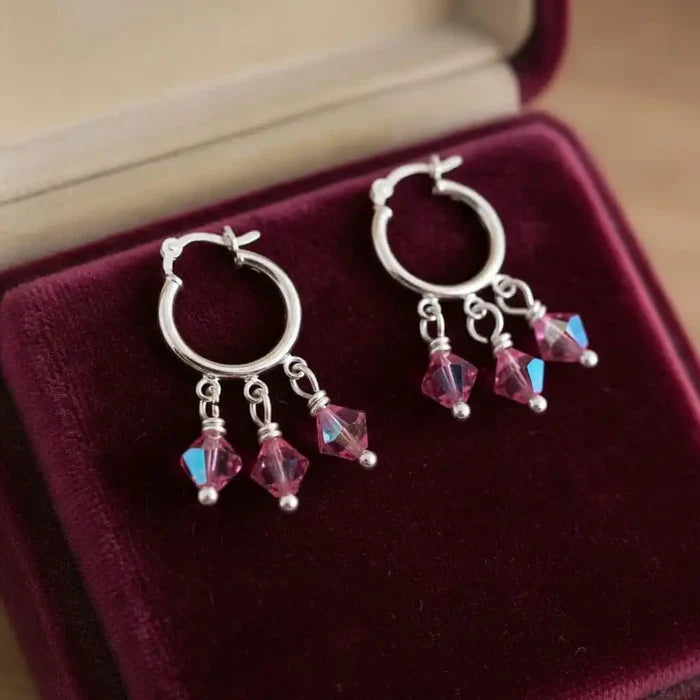 Mini Sterling Silver Hoop Pink Crystal Dangle Earrings displayed on a velvet jewelry box.