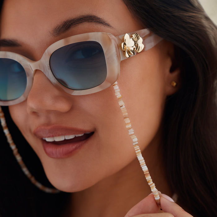 lifestyle - female wearing diff eyewear x disney princess featuring the moana square sunglasses with a beige tortoise acetate frame and seafoam green lenses detailed view