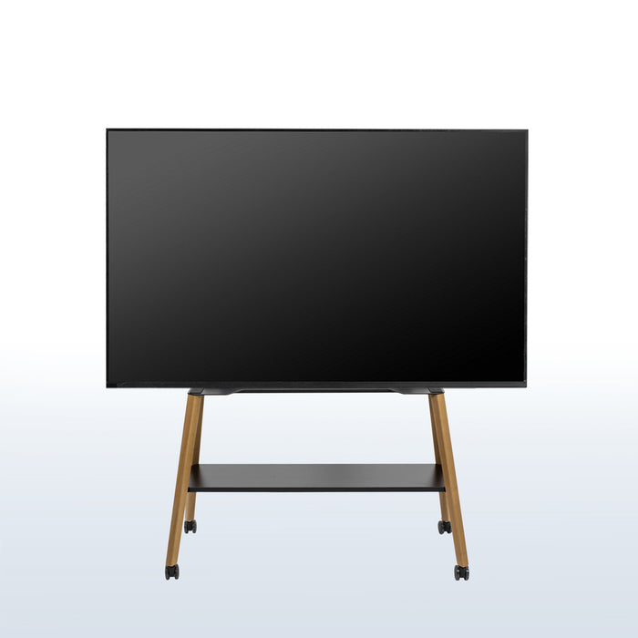 A large flat-screen display monitor on a wheeled easel TV stand with a black screen, slim black frame, and light wood legs, shown against a light gray gradient background.