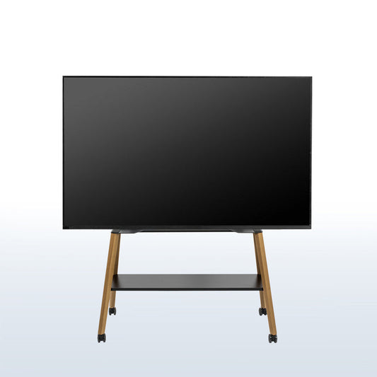 A large flat-screen display monitor on a wheeled easel TV stand with a black screen, slim black frame, and light wood legs, shown against a light gray gradient background.