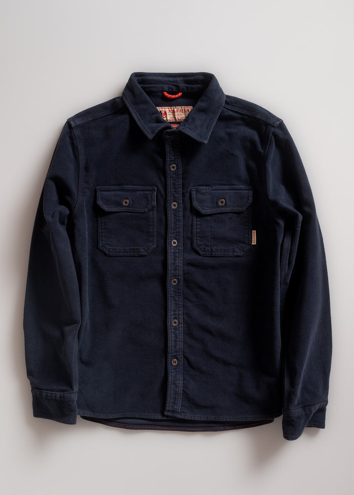 Navy blue button-up shirt with two chest pockets, laid flat on a white background, showcasing its classic design and texture.