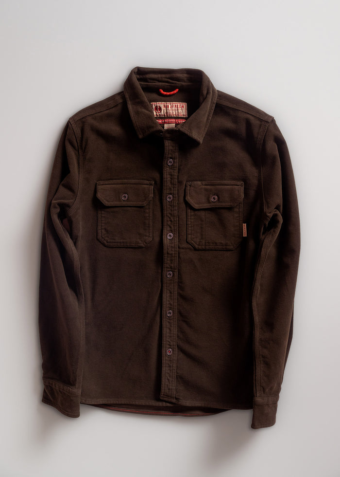 Dark brown button-up shirt with two chest pockets, laid flat on a light background. Red tag visible inside the collar.