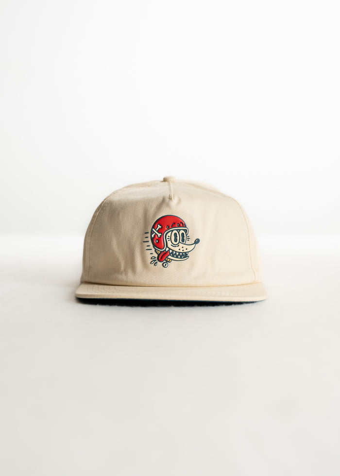 Beige cap with a colorful cartoon face embroidered on the front, set against a plain white background.