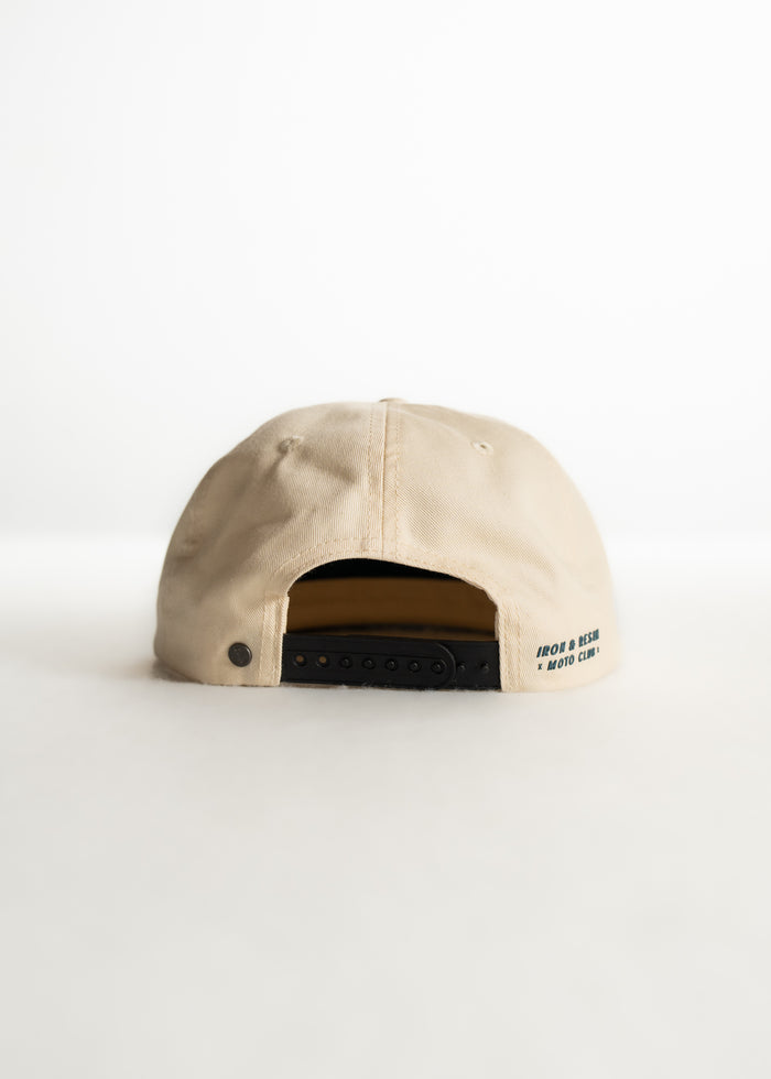 Beige cap with adjustable strap, text "IRON & RESIN MOTO CLUB" on the back, displayed against a plain white background.