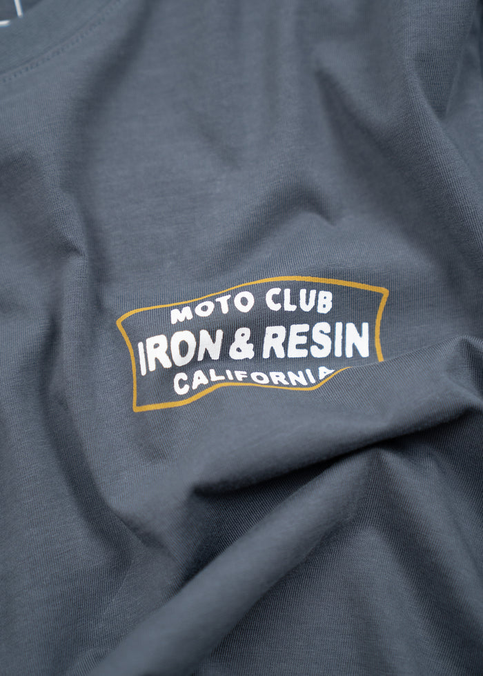 Gray shirt with "Moto Club Iron & Resin California" logo in white and yellow. Fabric is slightly wrinkled.