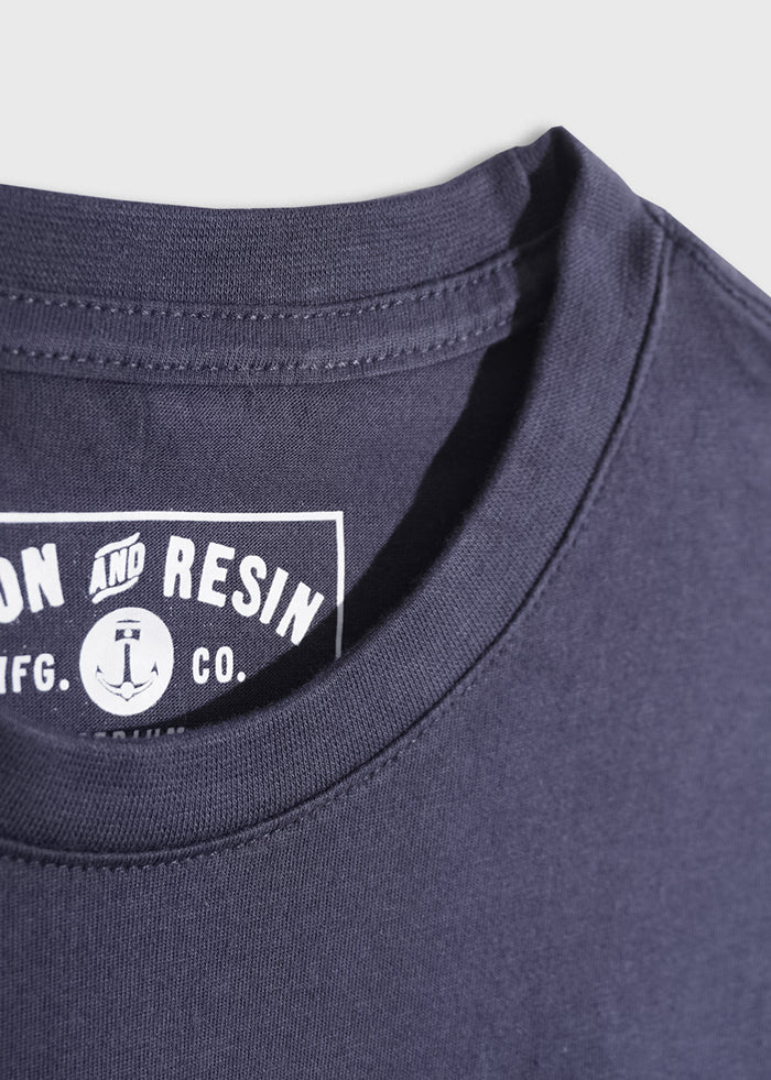 Close-up of a navy t-shirt collar with "Iron and Resin" logo inside. Simple design on a plain white background.