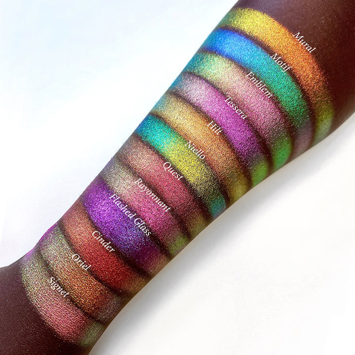 Top angled arm swatches on deep skin tone of Mural Electric Multichrome eyeshadow shifts compared to Motif, Emblem, Tessera, Hilt, Niello, Quest, Rayonnant, Flashed Glass, Cinder, Oriel and SIgnet