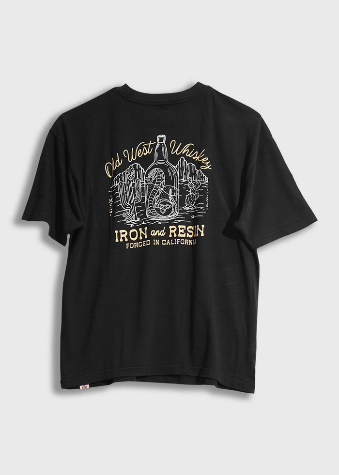 Black T-shirt with "Old West Whiskey" and "Iron and Resin" print, featuring a bottle and cacti, forged in California.
