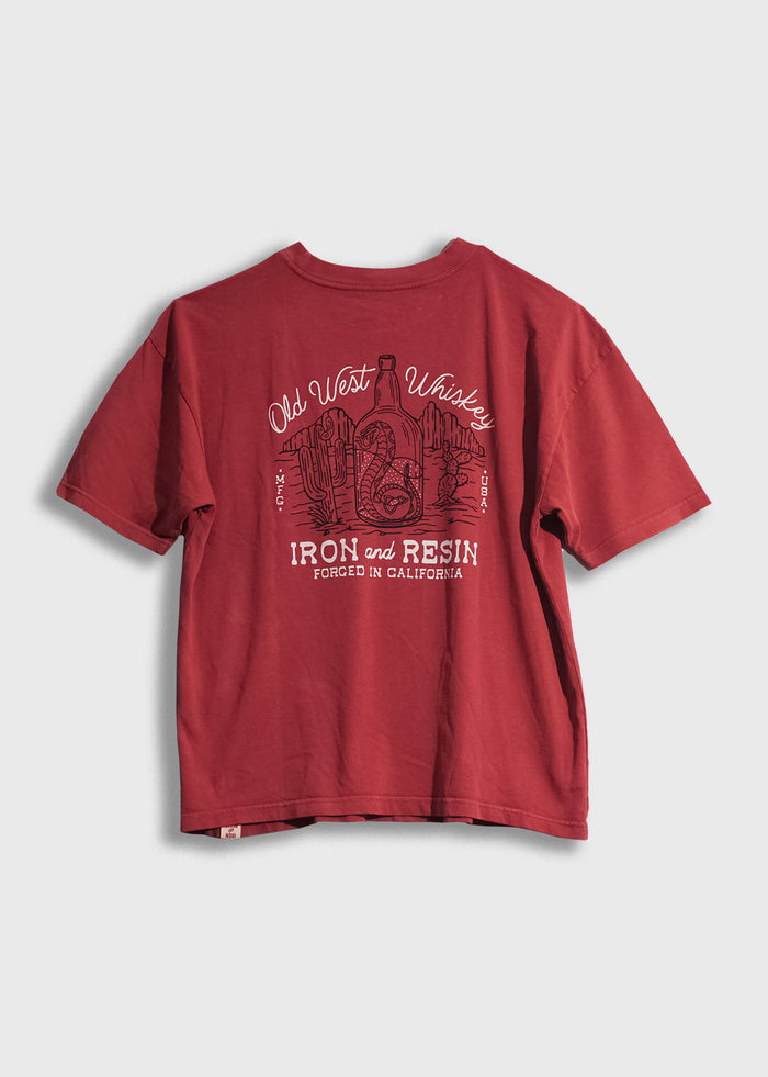 Red T-shirt with "Old West Whiskey" and "Iron and Resin" text, featuring a desert scene with cacti and a bottle design.