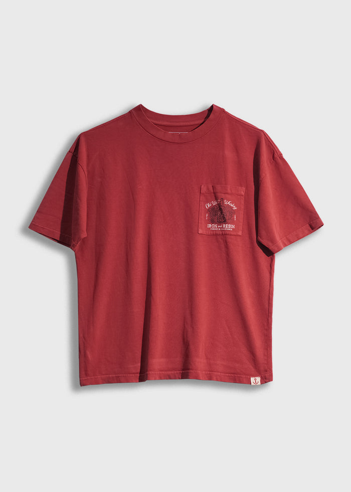 Red t-shirt with a chest pocket featuring a small "Iron and Resin" logo design, displayed on a plain white background.