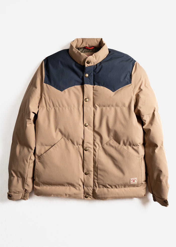 Tan puffer jacket with navy yoke, button closure, and front pockets, displayed on a white background.