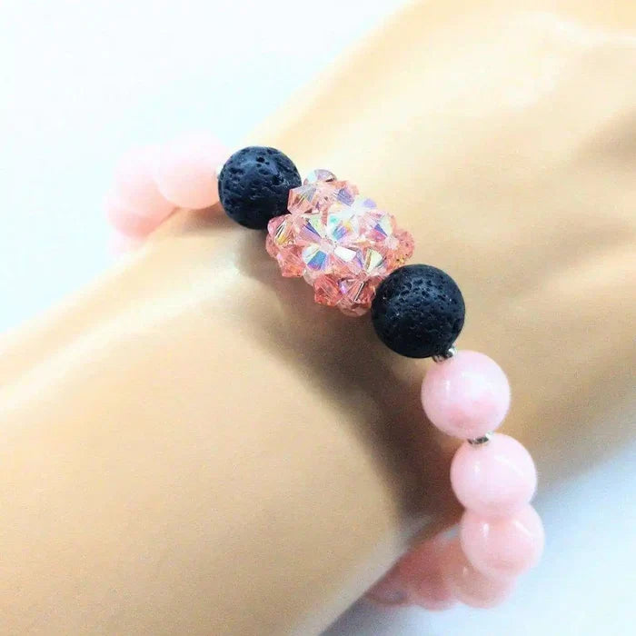Peach Corral Jade Gemstone Crystal Lava Rock Bracelet showcased on a wrist with pink and black beads.