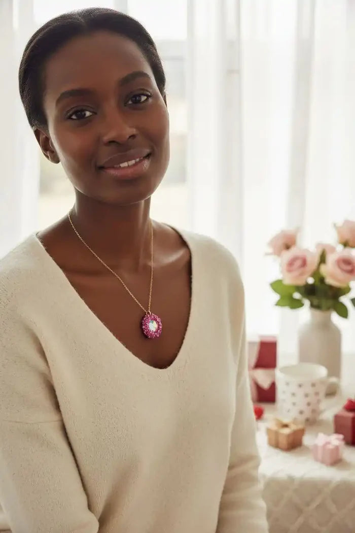Model wearing a Pink Beaded Super Sparkly Rivoli Crystal Necklace, showcasing its elegance and sparkle in a cozy setting.