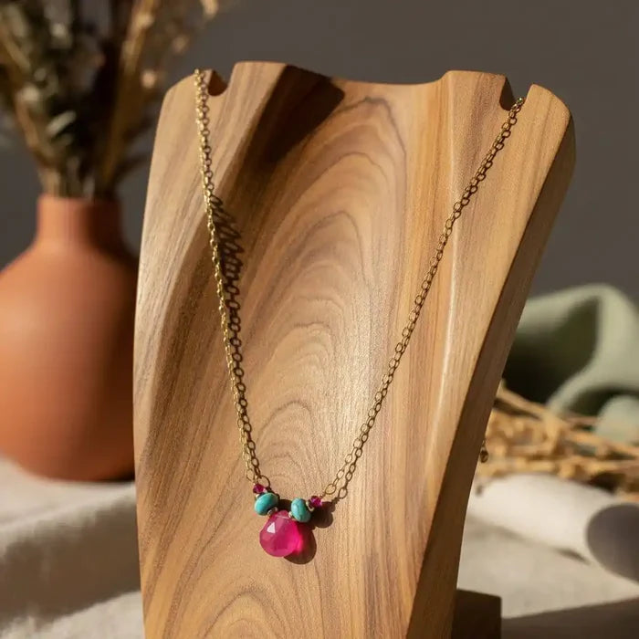 Gold Filled Turquoise and Pink Gemstone Drop Necklace displayed on a wooden stand with vibrant colors.